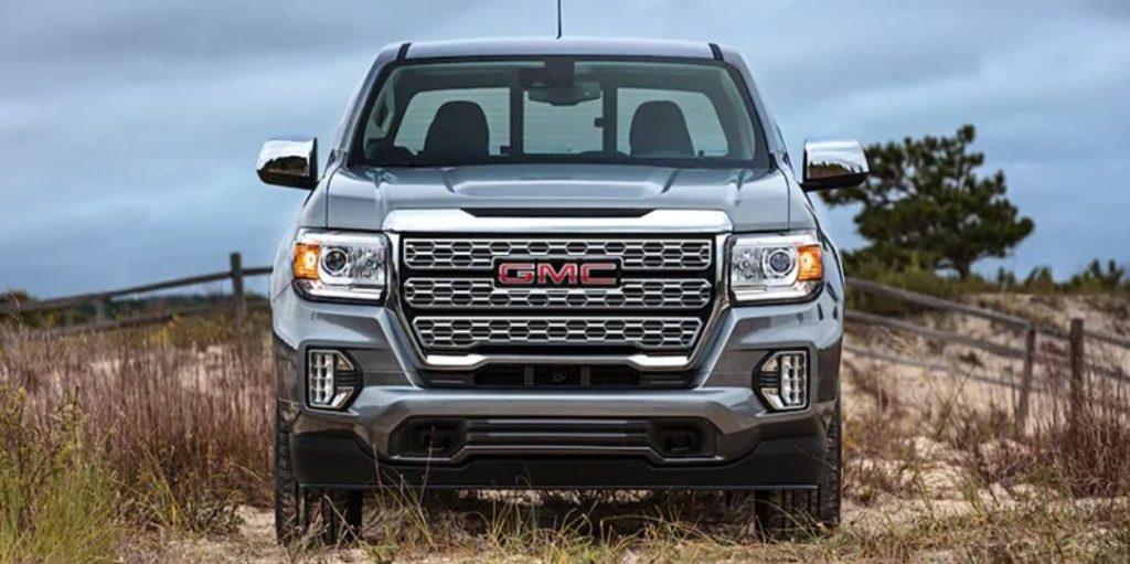 A head-on shot of a silver 2022 GMC Canyon in a field.