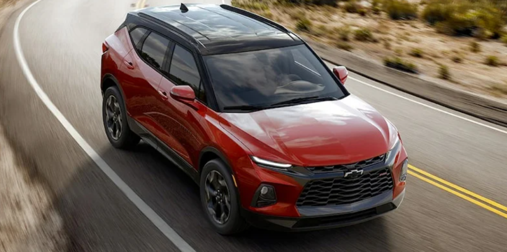 A red 2022 Chevrolet Blazer driving down a road.