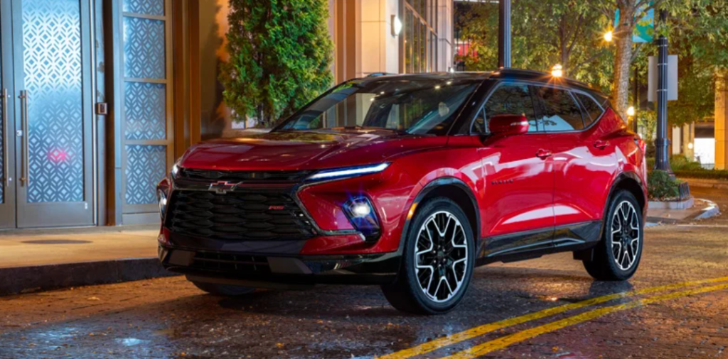 A red 2023 Chevrolet Blazer parked at nighttime in front of a building.