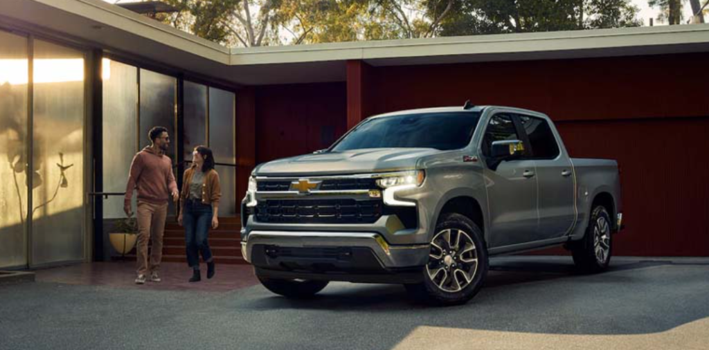 A couple getting ready to get inside their gray 2023 Chevrolet Silverado 1500.