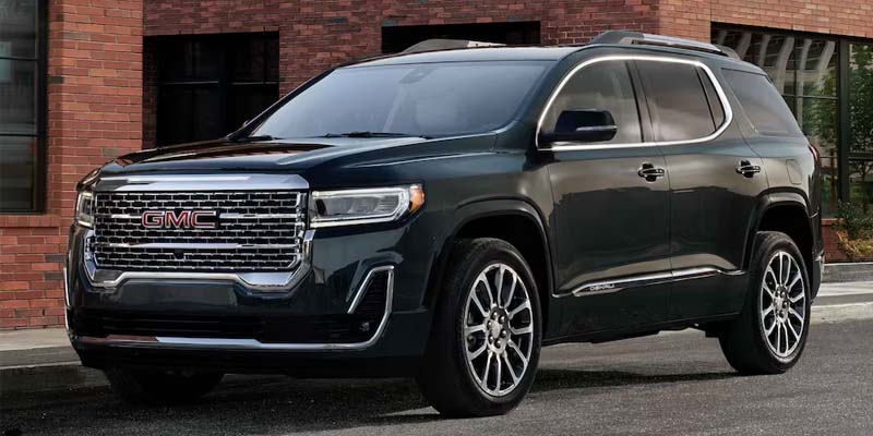 A black 2023 GMC Acadia parked on the street.