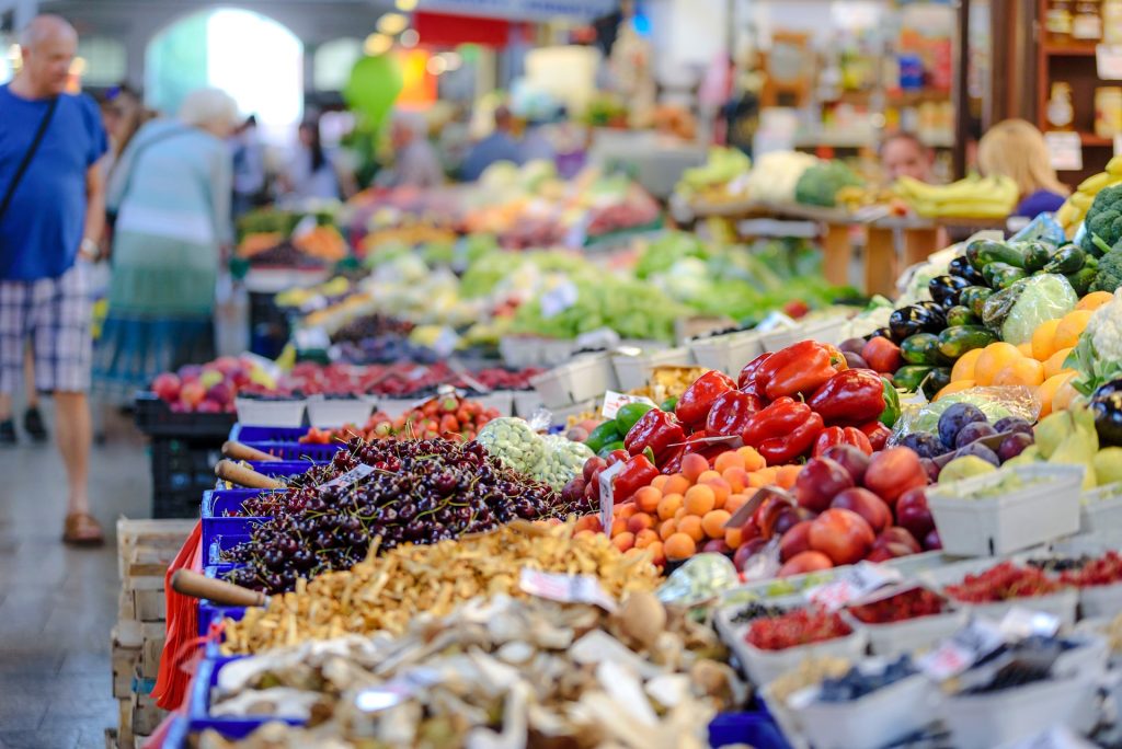 People shopping at an outdoor farmer's market.