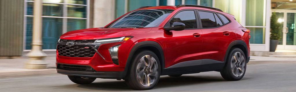 Red Chevrolet Equinox SUV driving through a city street
